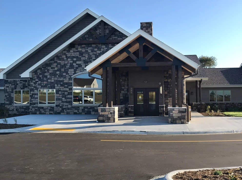A modern building with a stone exterior and prominent entrance.