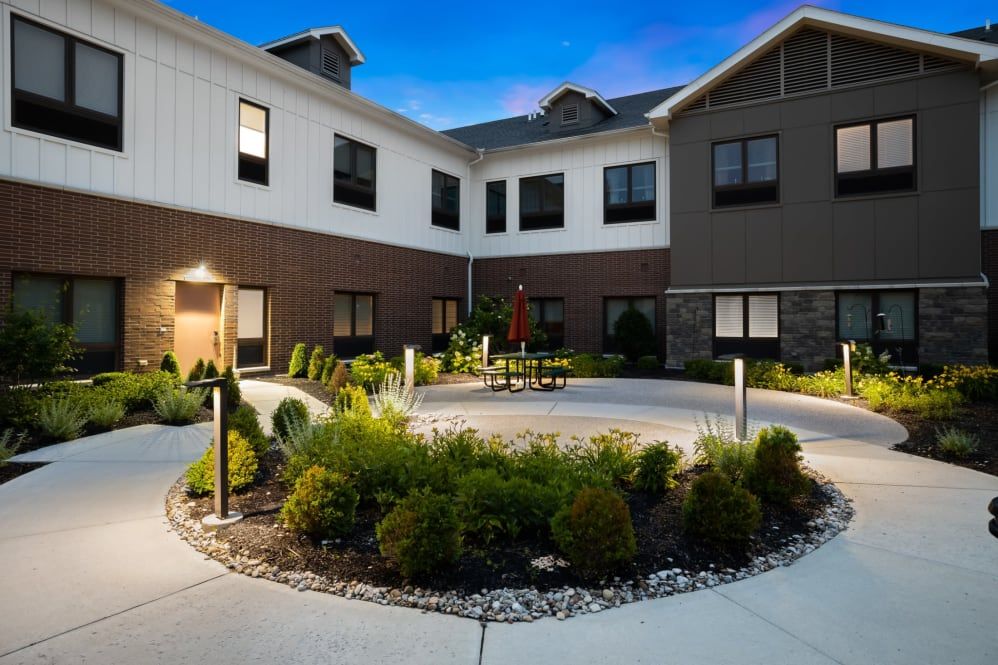 A modern building with a landscaped courtyard and evening lighting.