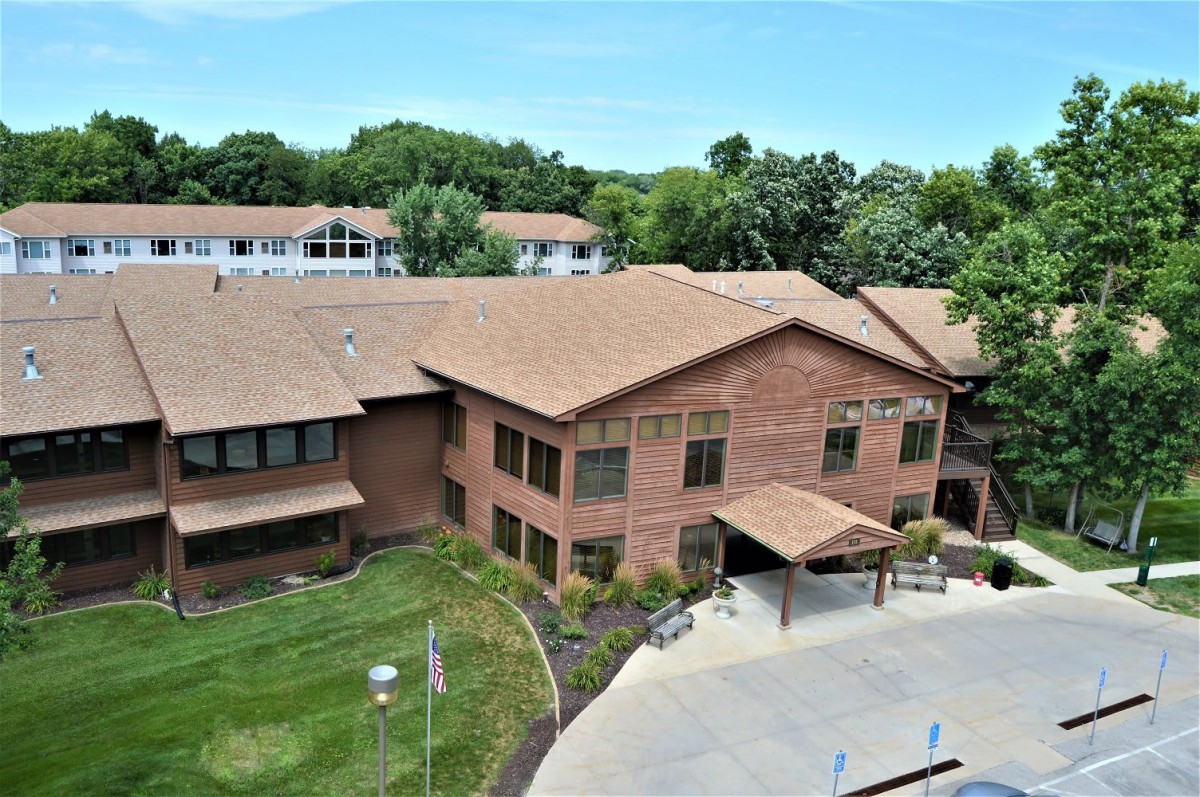 Aerial view of a brick building surrounded by greenery.
