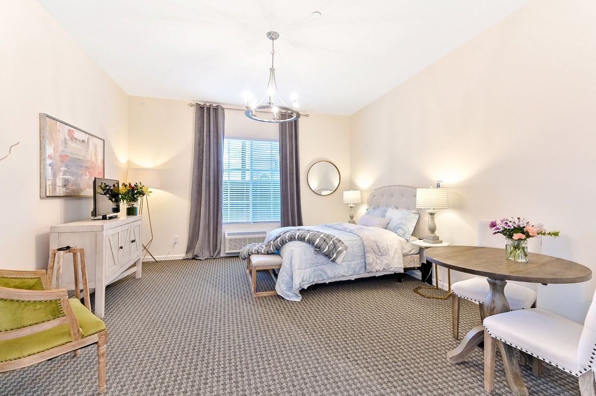 A well-lit modern bedroom with stylish decor and comfortable furnishings.