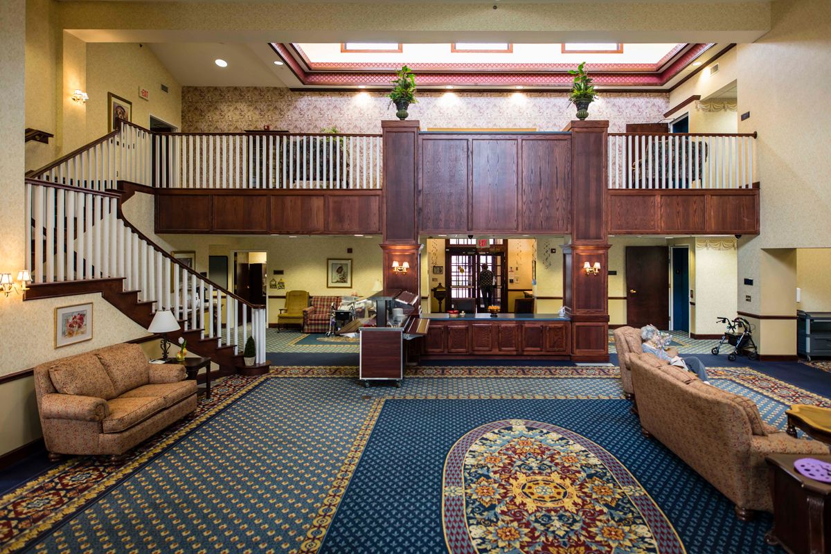 A spacious hotel lobby featuring elegant furniture and a reception desk.