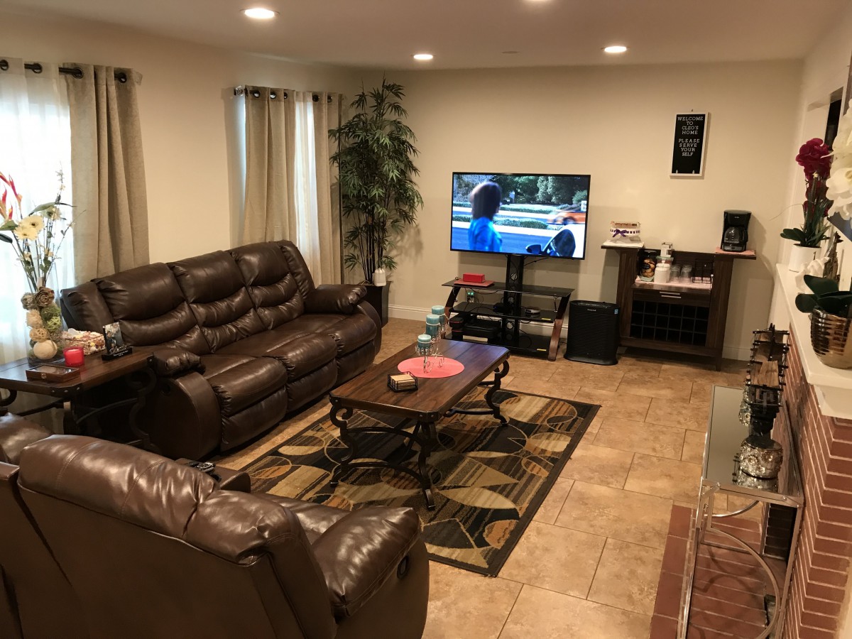 A cozy living room with a leather sofa, TV, and coffee table.