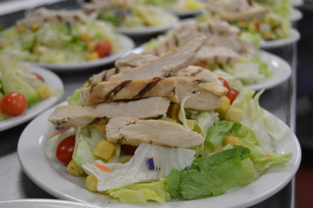A fresh chicken salad with lettuce, cherry tomatoes, and corn.