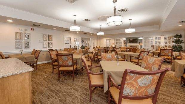 A well-lit dining area featuring neatly arranged tables and chairs with elegant decor.