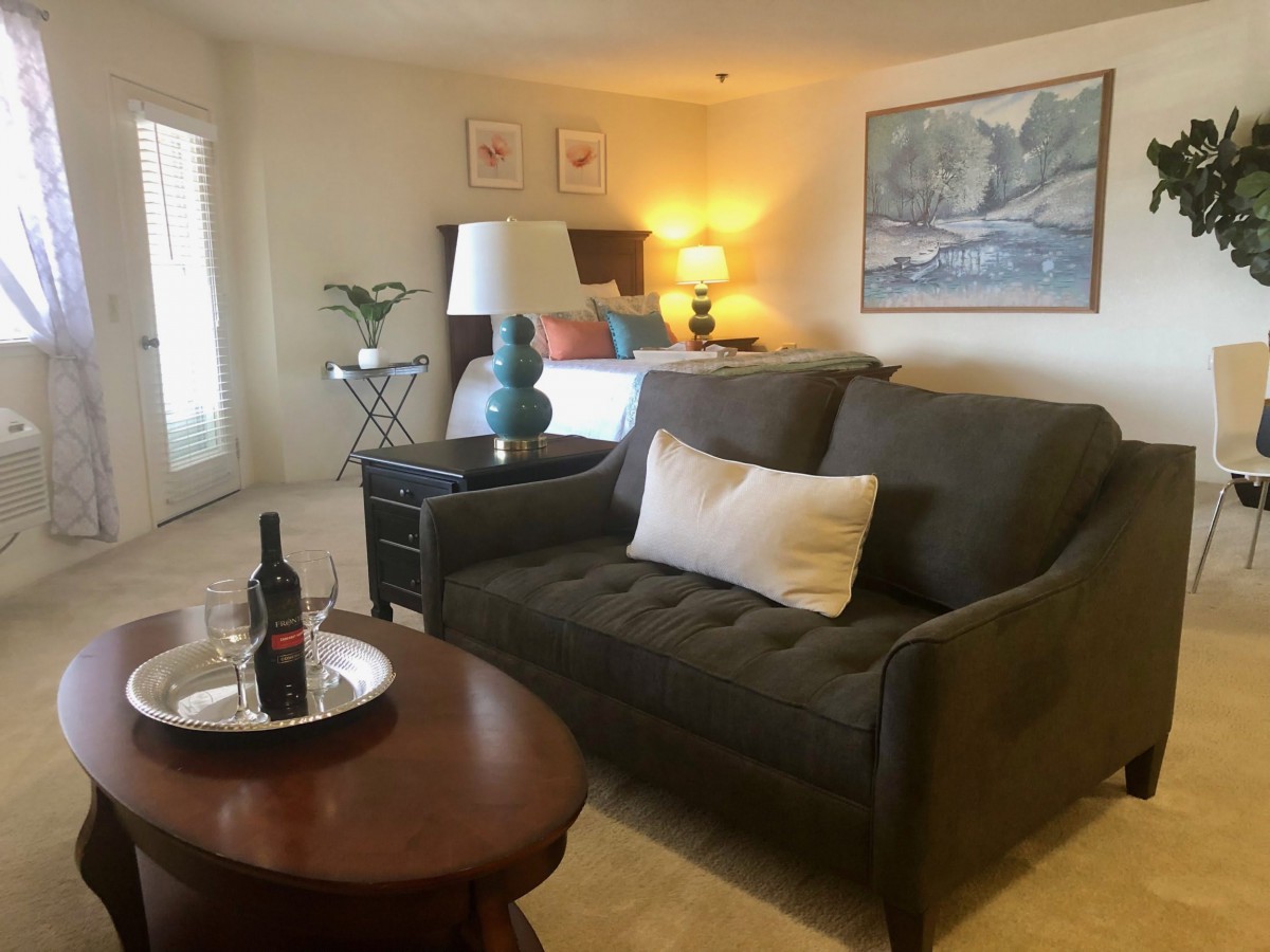 A cozy living room with a sofa, coffee table, and warm lighting.