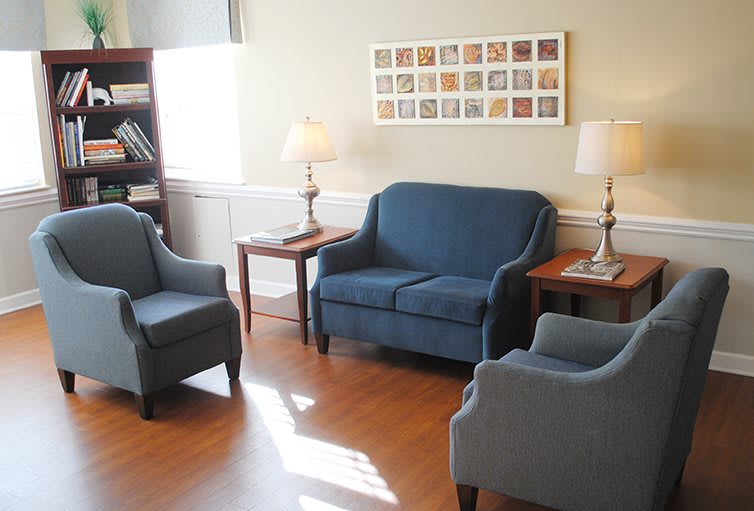 A cozy living room featuring blue upholstered furniture and warm lighting.