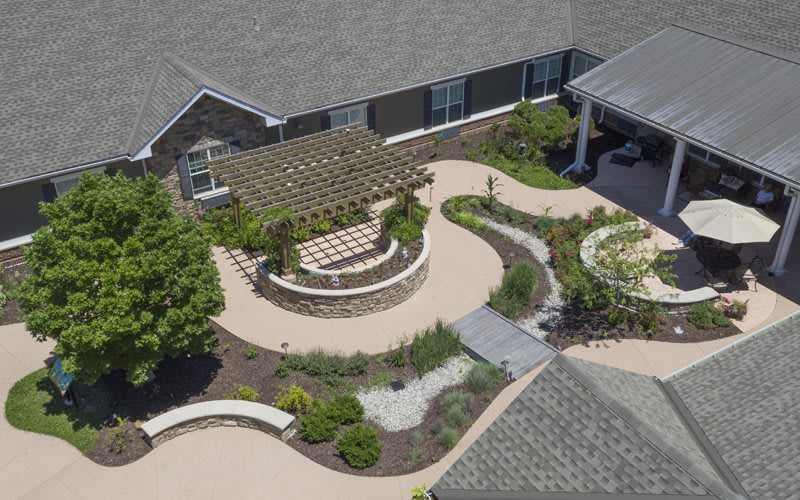 Aerial view of a landscaped patio area with a pergola and garden pathways.