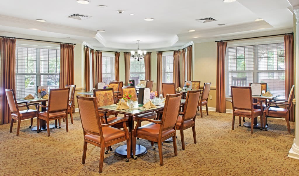 A spacious and elegantly decorated dining room with neatly arranged tables and chairs.