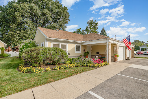 A charming residential home with a well-maintained garden and clear blue skies.