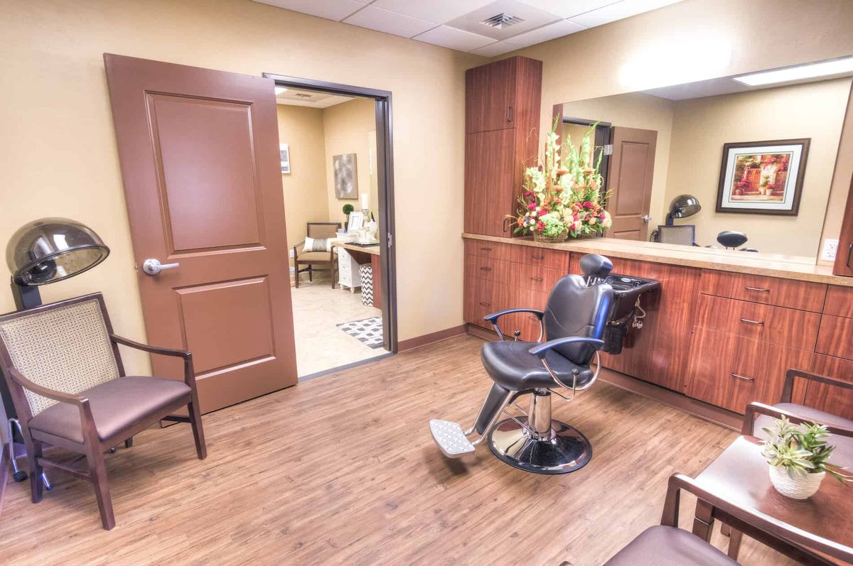 Interior of a hair salon with a barber chair and waiting area.