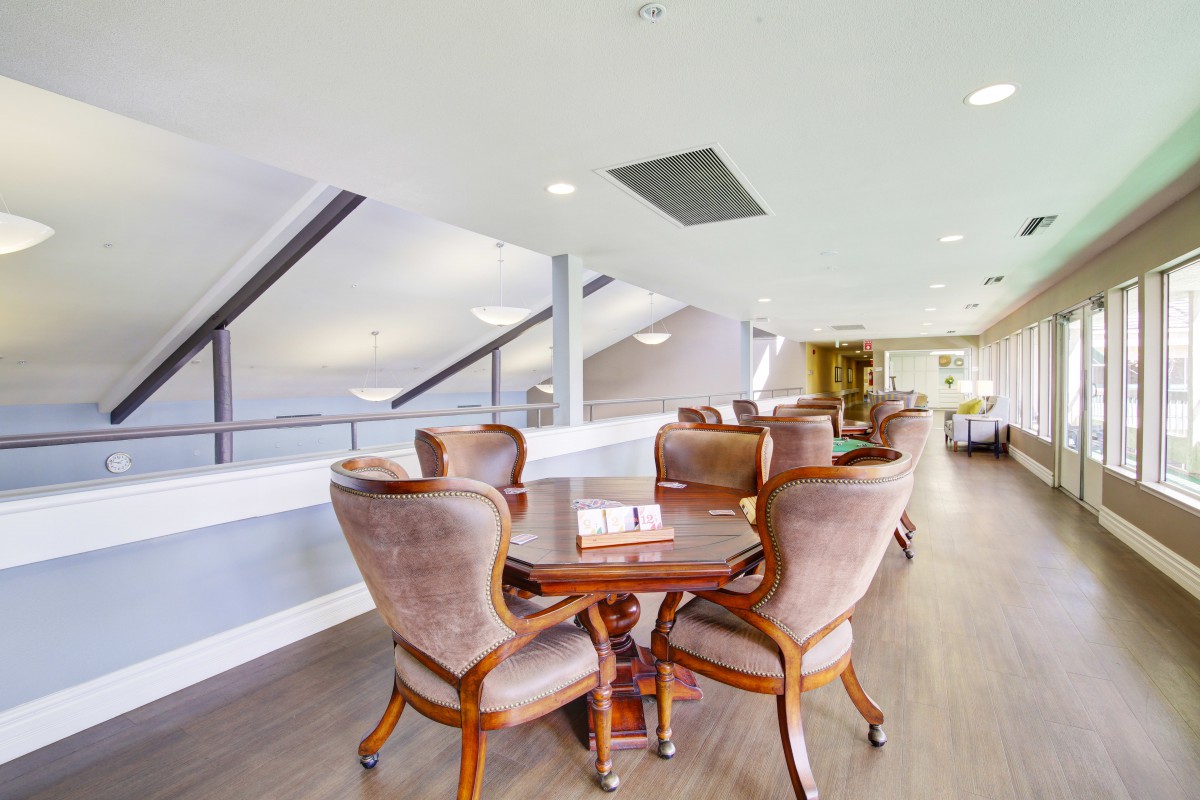 A modern and spacious interior with elegant furniture, featuring a wooden dining table surrounded by comfortable chairs.