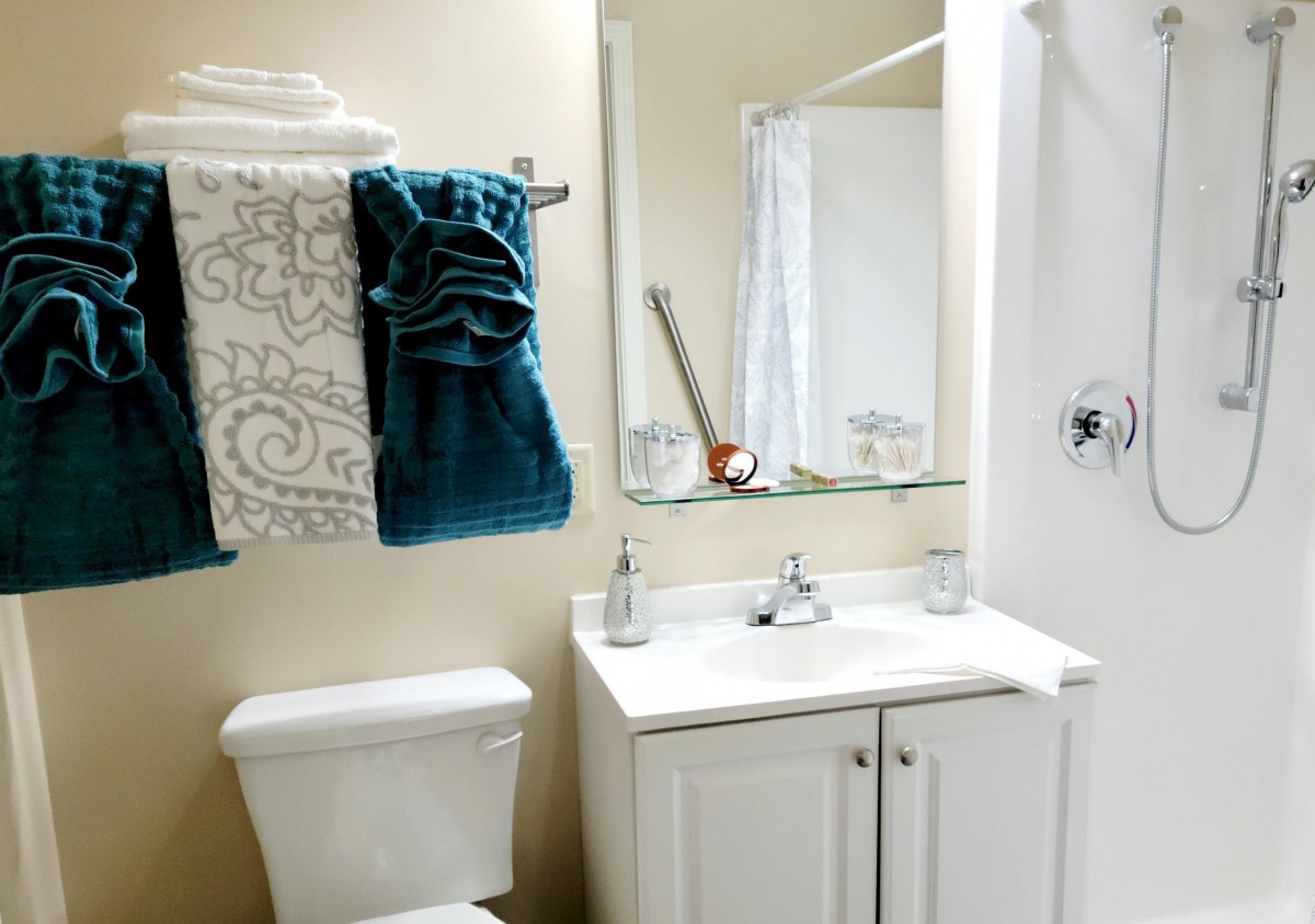 A neatly arranged bathroom with a sink, mirror, and towels.