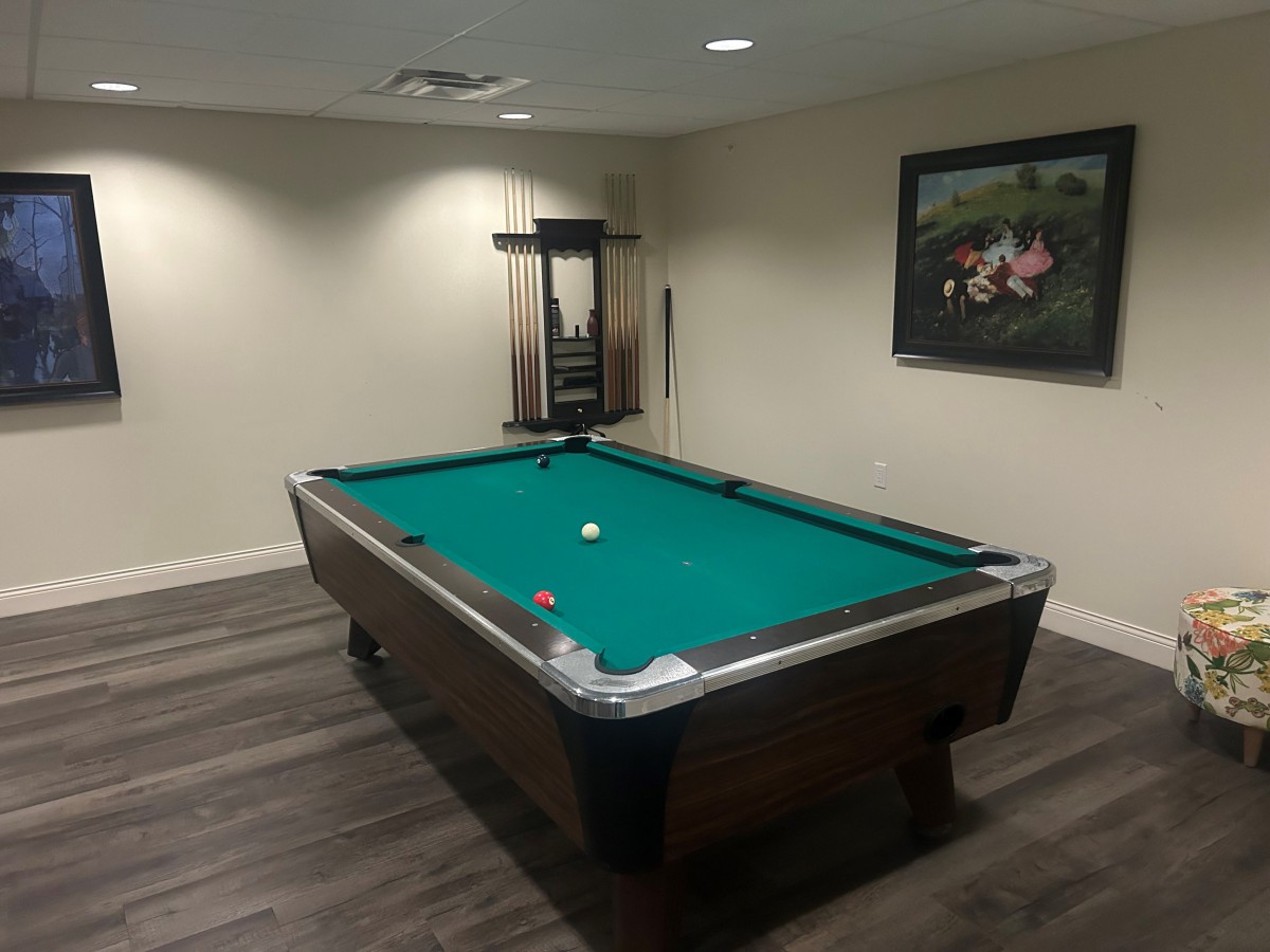 A cozy game room featuring a pool table ready for a round of billiards.