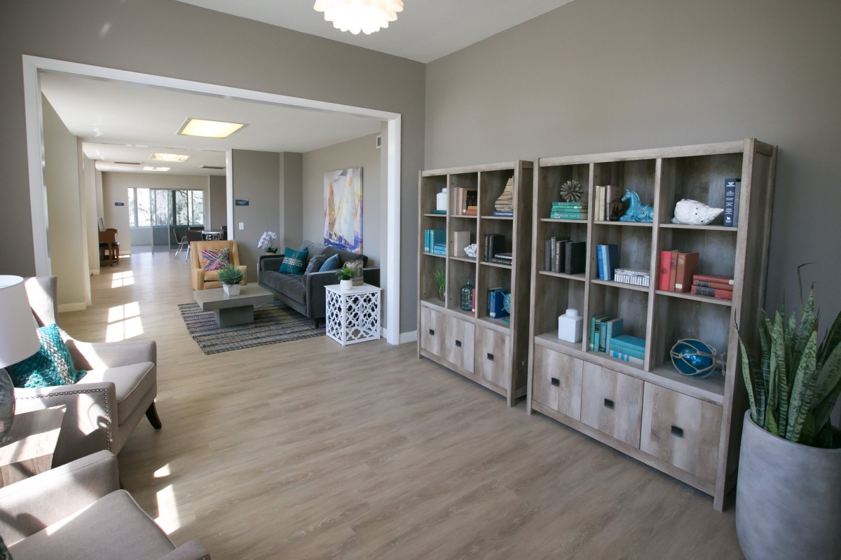 A modern living room with bookshelves and comfortable seating in an open, well-lit space.
