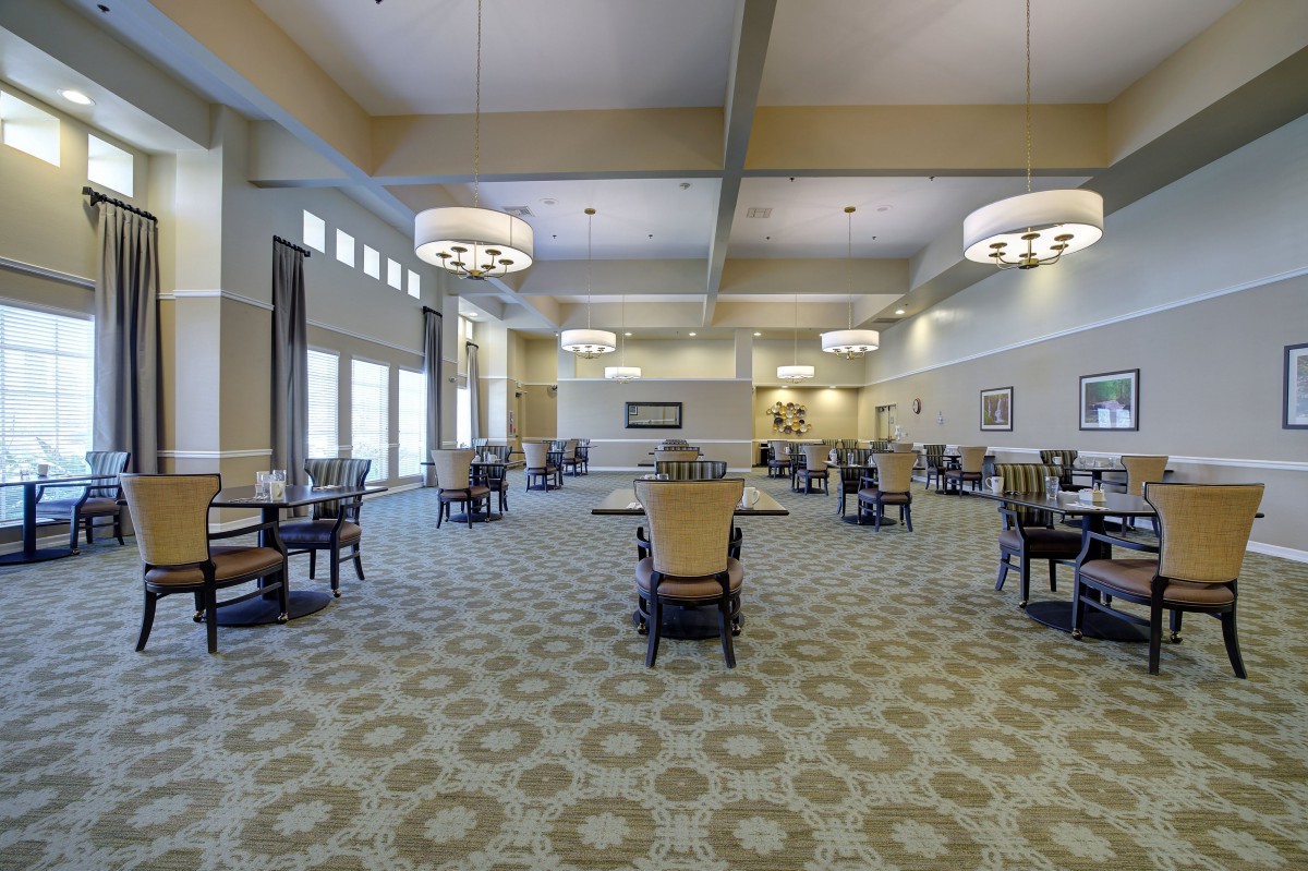 Spacious dining area with modern furniture and decorative lighting.