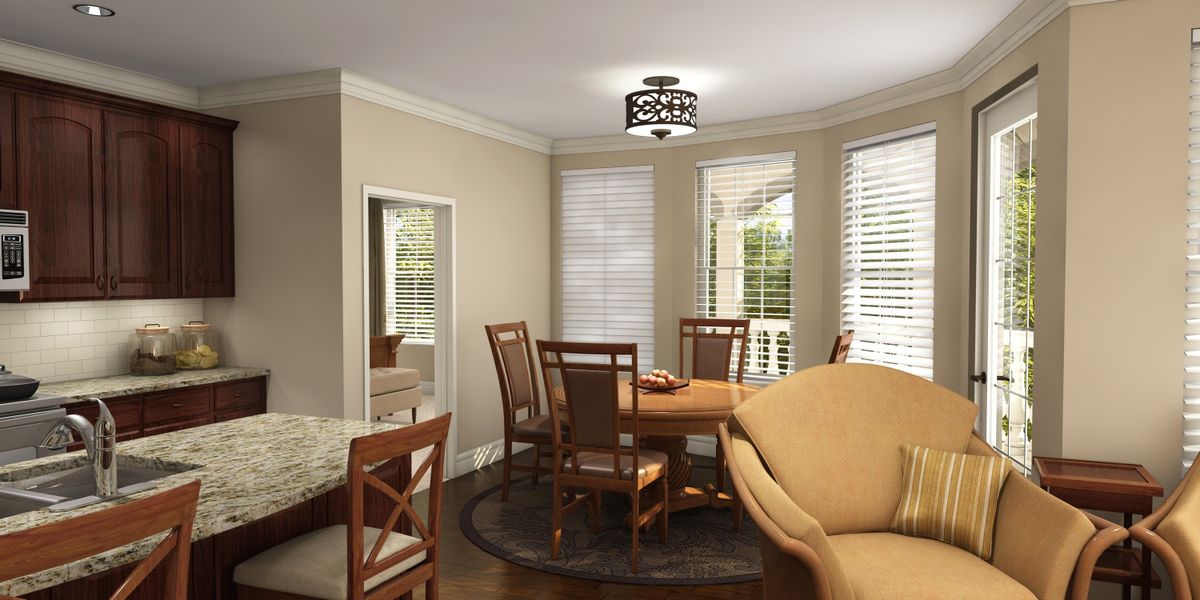 A cozy dining room with a wooden table, chairs, and a sofa near large windows with blinds, featuring a stylish ceiling light.