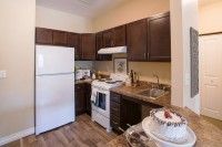 A compact kitchen with dark cabinets and white appliances.