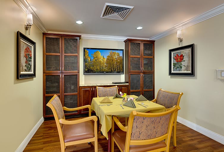 A cozy dining room with wooden furniture and decorative artwork on the walls.