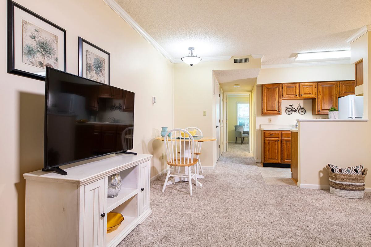 Cozy living room with a TV, adjacent dining area, and kitchen.