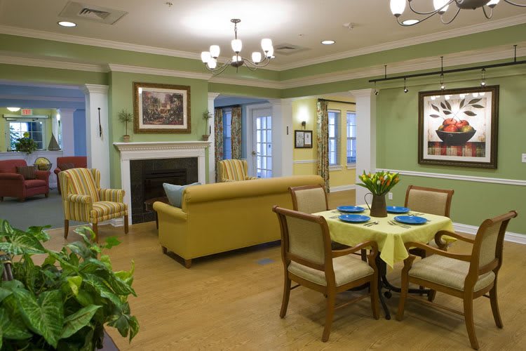 A cozy living and dining area with green walls, elegant furniture, and a welcoming atmosphere.