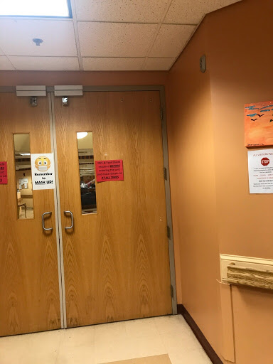 Entrance to a facility with visible signage and wooden double doors.