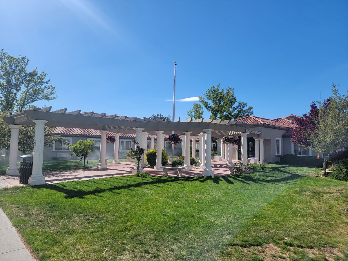 A sunny day view of a house with a well-maintained lawn and garden.