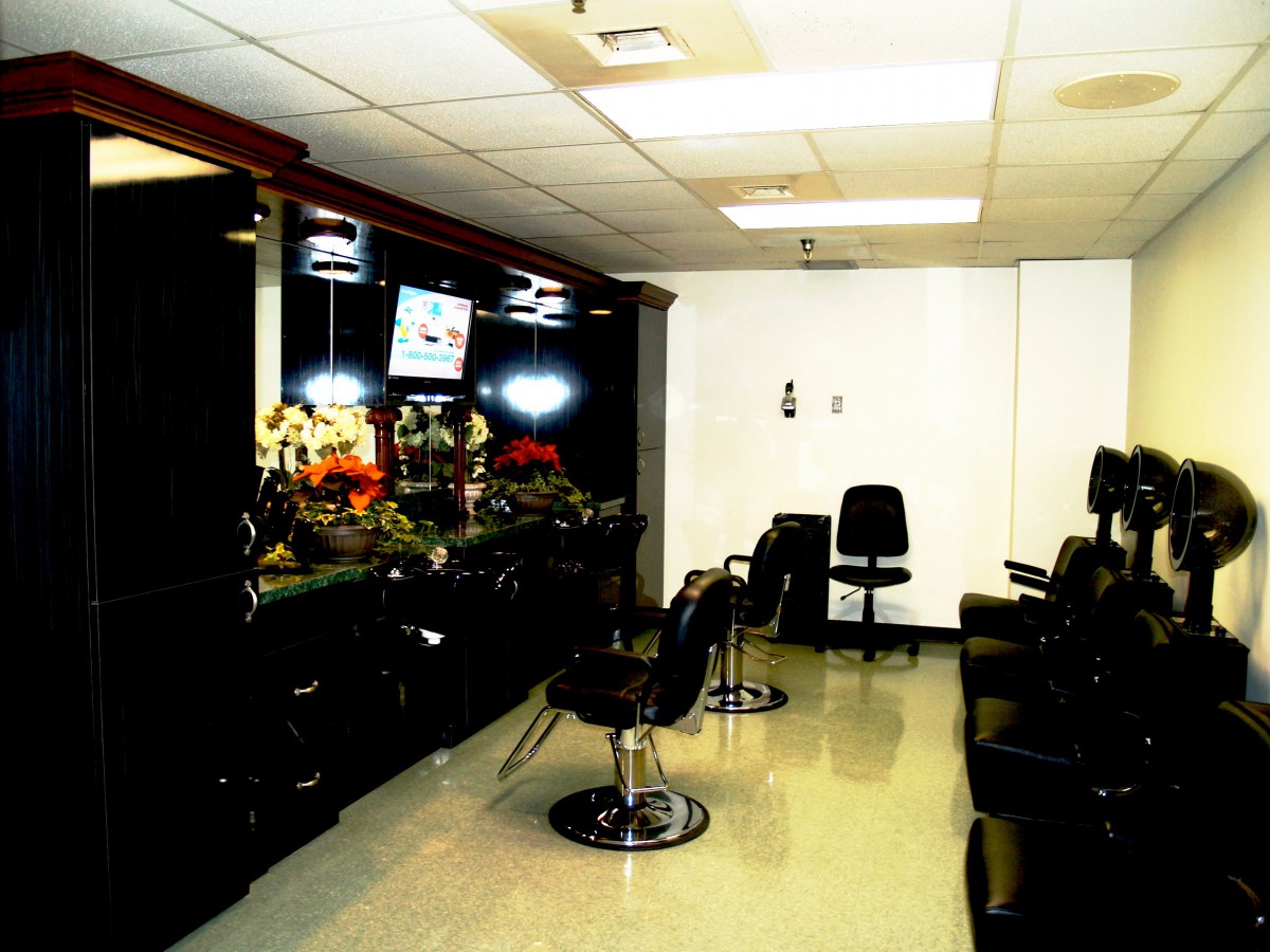 Interior view of an empty hair salon with multiple chairs and mirrors.