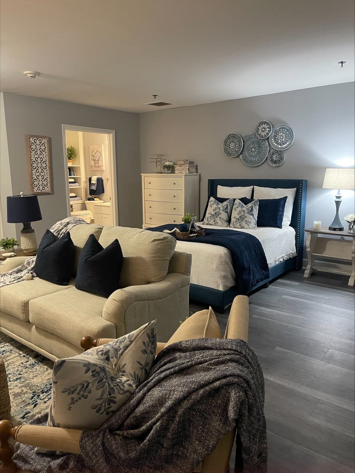 A stylish bedroom with an adjacent living area, featuring a cozy sofa and a well-appointed bed.