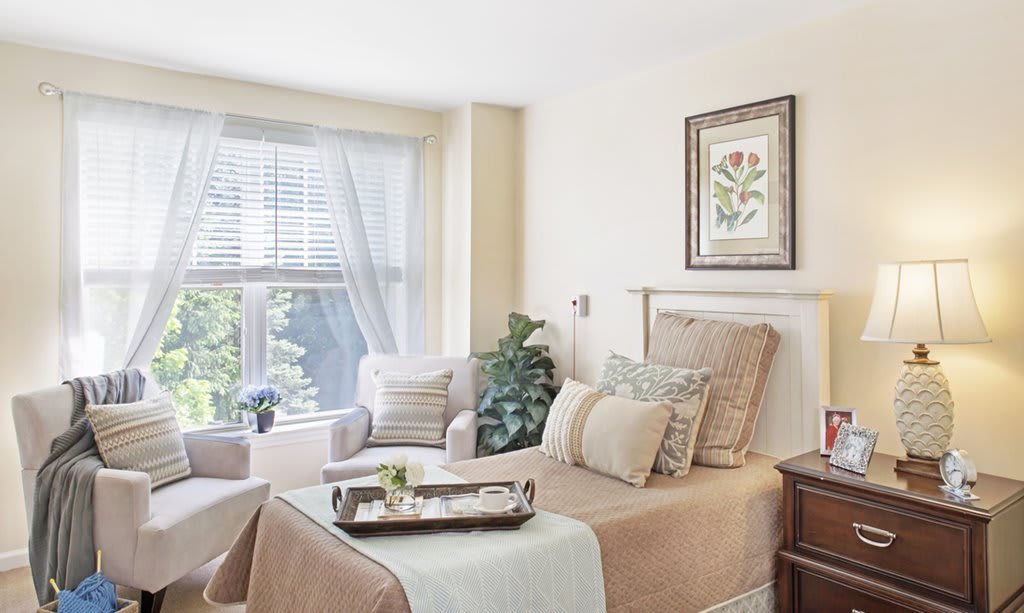 A cozy bedroom with neutral tones and ample natural light.