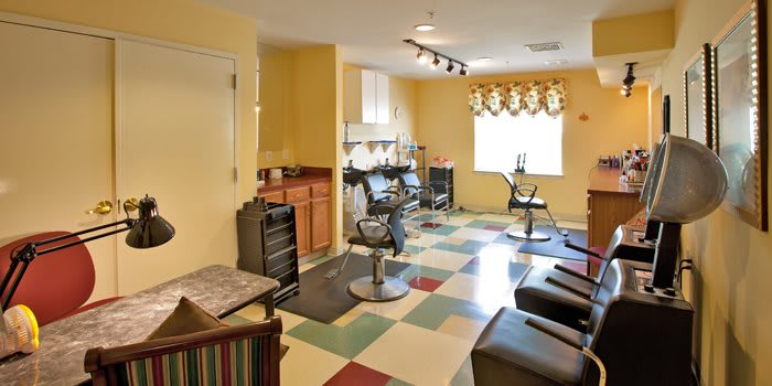 An empty hair salon with colorful flooring and multiple barber stations.