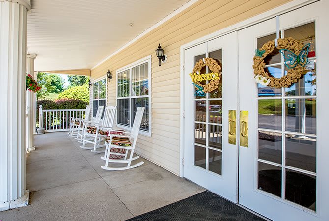 A welcoming porch with rocking chairs and decorative doors.