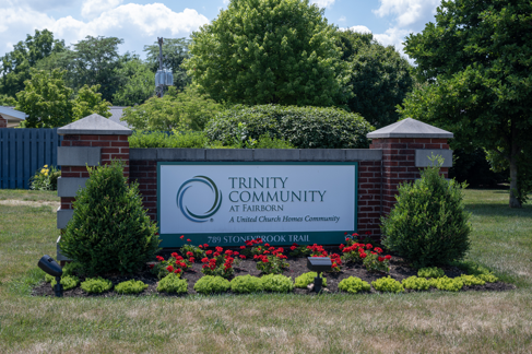 Entrance sign for Trinity Community, surrounded by well-maintained landscaping.