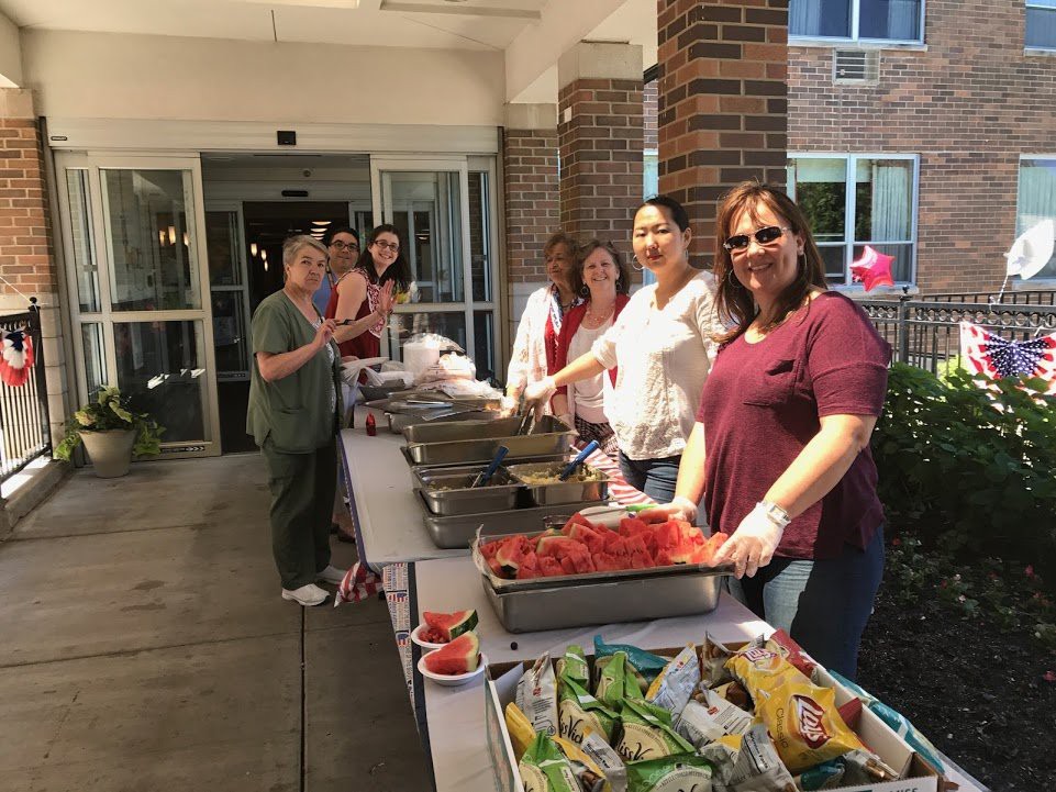A group of volunteers serving food at an outdoor community event.