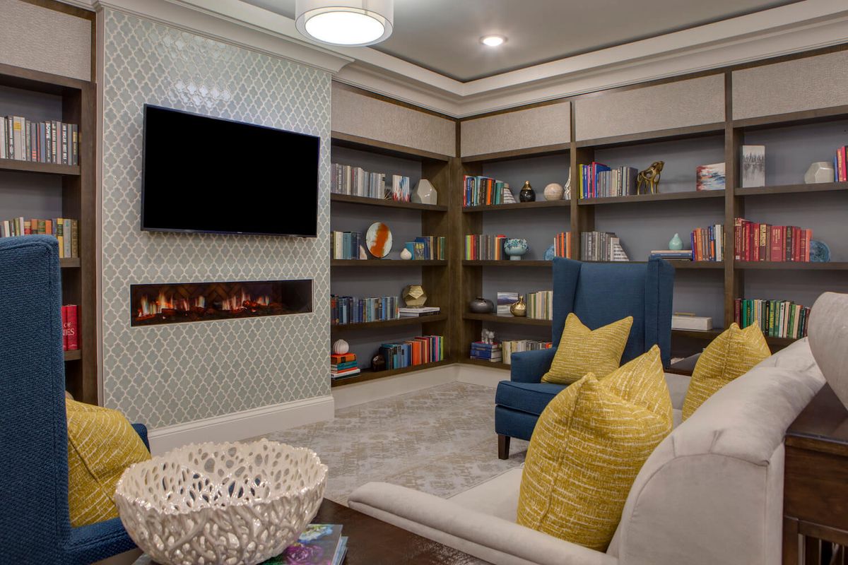 A cozy living room with bookshelves, a fireplace, and comfortable seating.