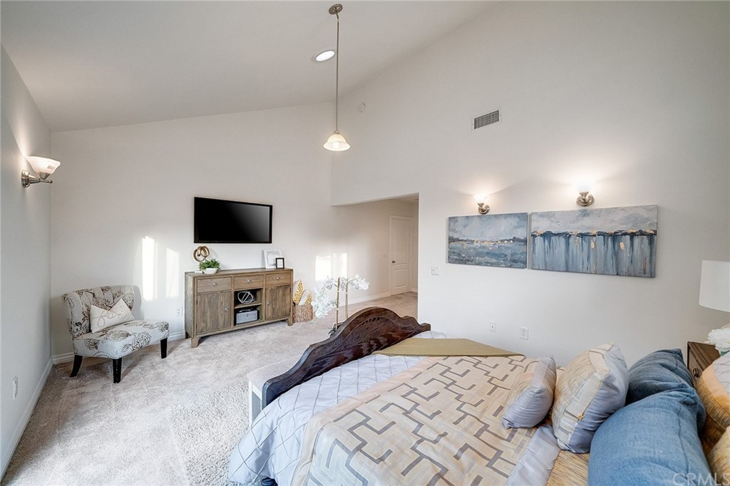 A modern bedroom with neutral tones, featuring a comfortable bed and stylish decor.