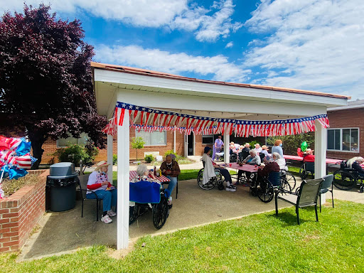 A lively community gathering under a decorated patio, filled with joyful conversations and summer sunshine.