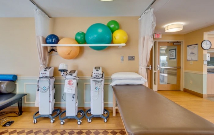A physical therapy treatment room equipped with exercise machines and therapy balls.