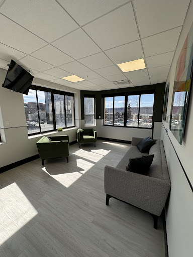 A bright and modern lounge area with comfortable seating and large windows.