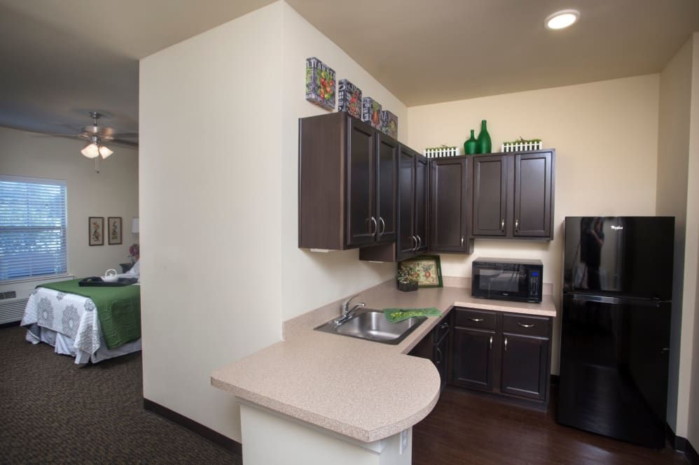 A modern kitchen with dark cabinets, a microwave, and a compact countertop layout.