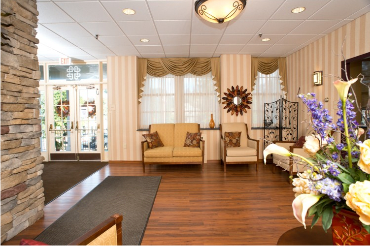 A cozy lobby with seating area, wooden floors, and decorative elements.