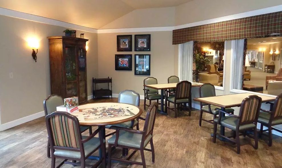A cozy room with multiple tables and chairs, featuring a puzzle in progress on one table.