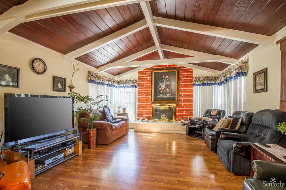Spacious living room with a vaulted ceiling and brick fireplace.
