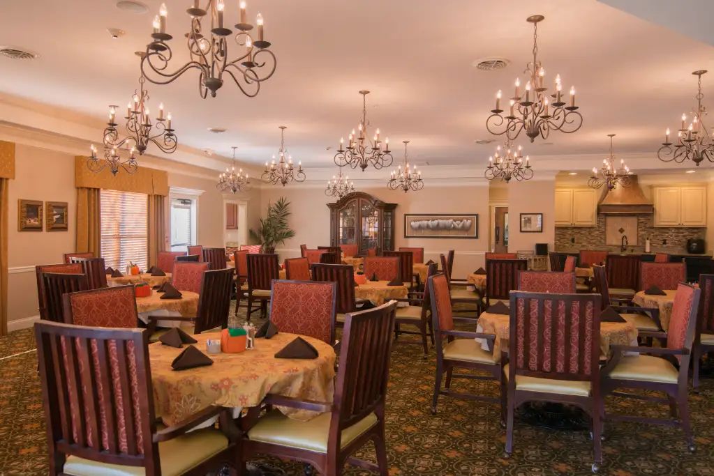 An elegant dining room with chandeliers and neatly arranged tables.