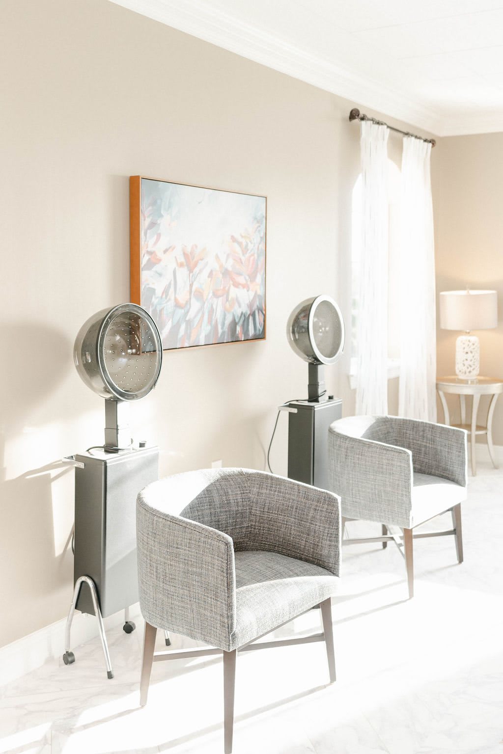 A modern salon interior with hair drying stations featuring stylish chairs and sleek hair dryers.