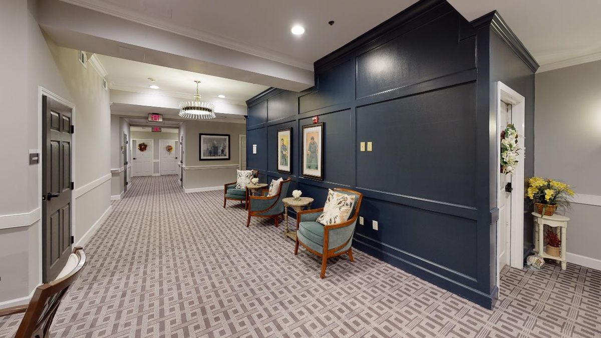 A cozy hallway with seating and artwork on the walls.