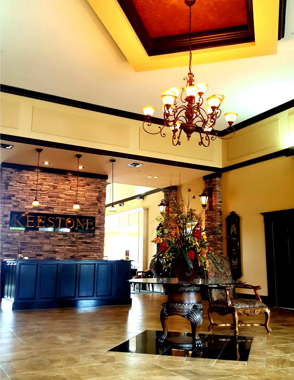 Elegant lobby area with chandelier, reception desk, and decorative elements.