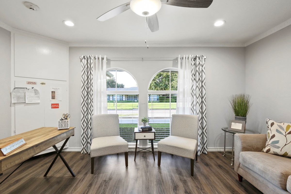 A modern living room with sleek armchairs and large windows allowing natural light to fill the space.
