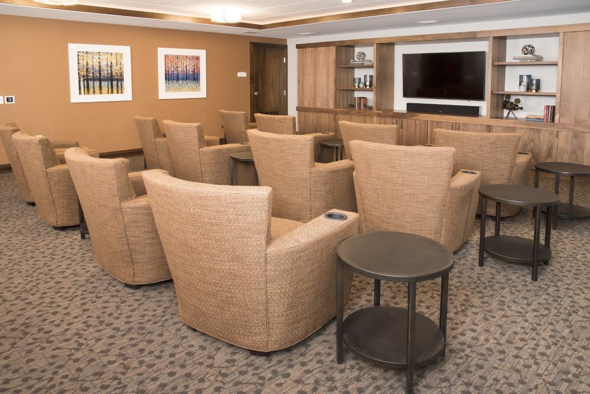 A modern conference room with comfortable seating and a large television.