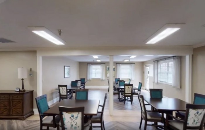 A spacious dining area with several tables and chairs, well-lit with natural light.