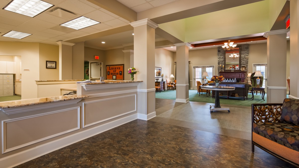 A spacious and well-lit lobby area featuring a reception desk and comfortable seating.